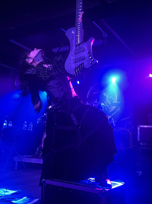 A picture of JILUKA bassist throwing his hair back